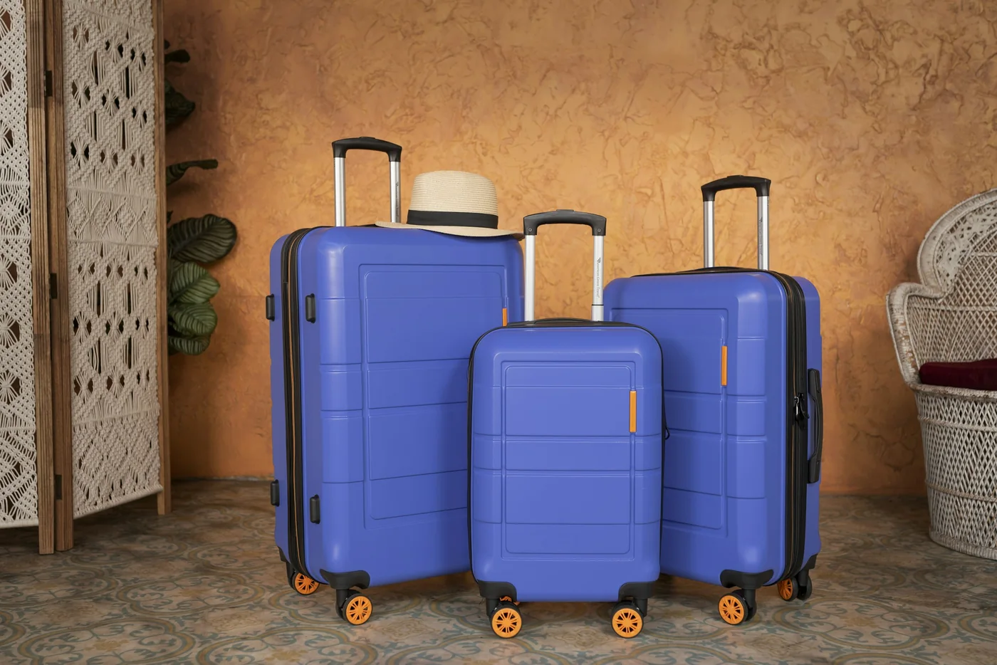 Three blue hard-shell suitcases in different sizes