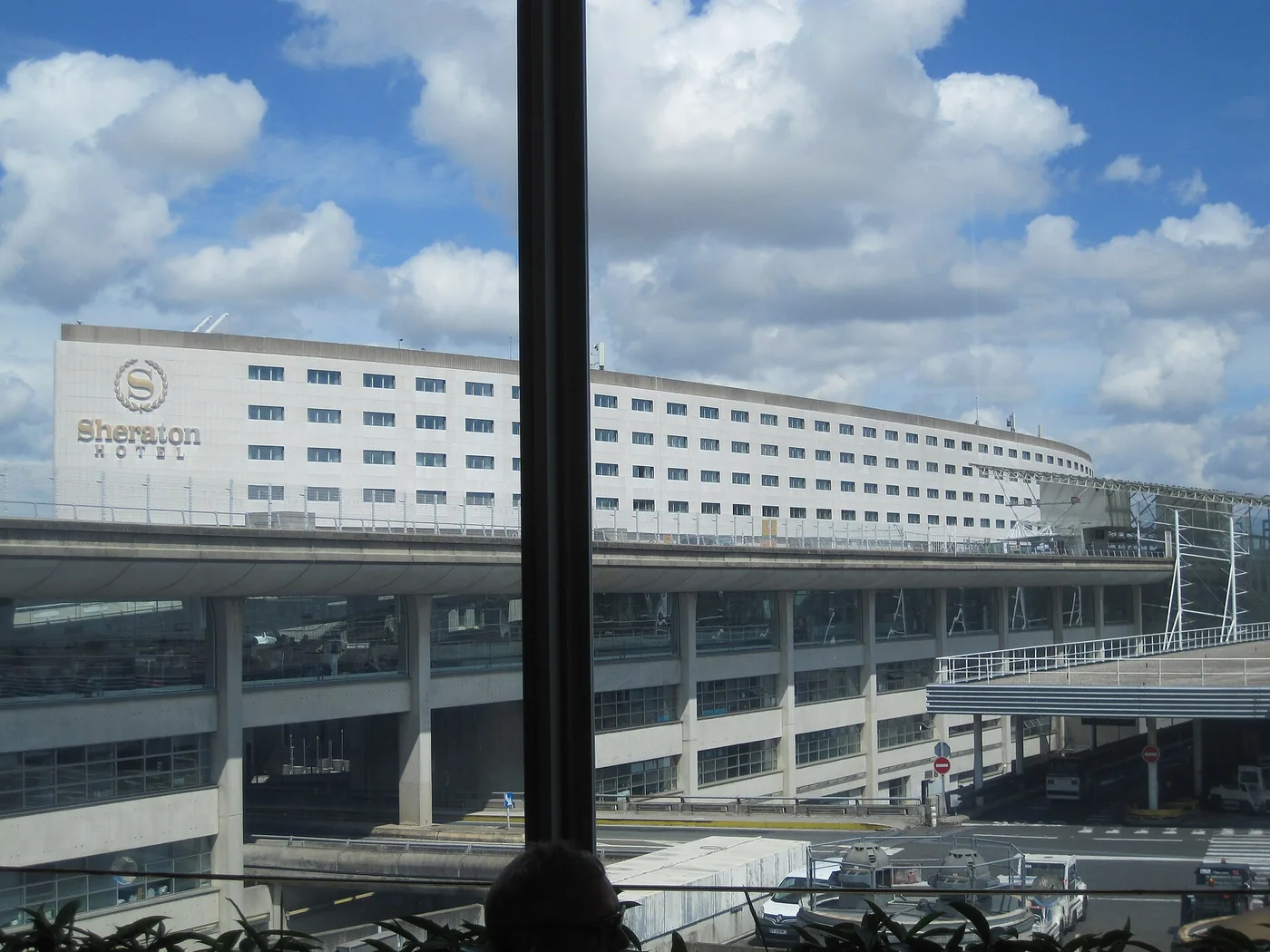 The Sheraton hotel building at Charles de Gaulle Airport viewed through terminal windows